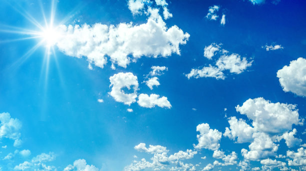 美丽清澈的春天天空和明亮的白天太阳和白色蓬松的云图片下载