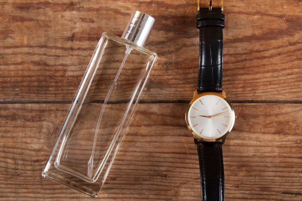 木制背景上的男士手表和香水。图片下载