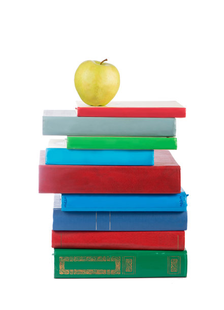 一堆书和苹果被孤立在白色的背景上图片下载