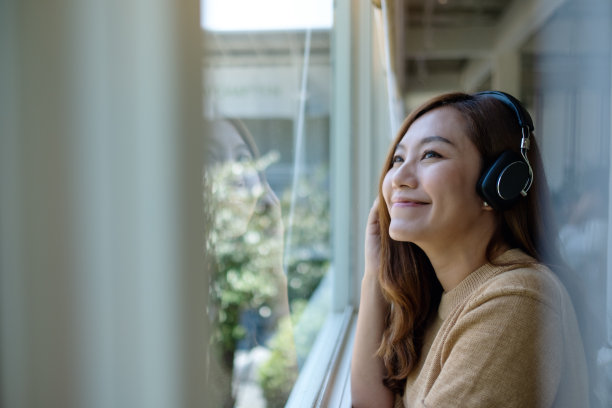 一位年轻美丽的亚洲妇女喜欢用耳机听音乐图片下载