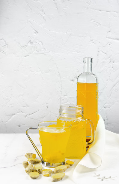 垂直照片与两个玻璃杯和一瓶柠檬生姜康普茶-益生菌发酵茶。图片下载