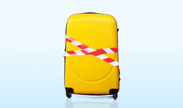 彩色的行李用红白相间的胶带包裹着图片下载