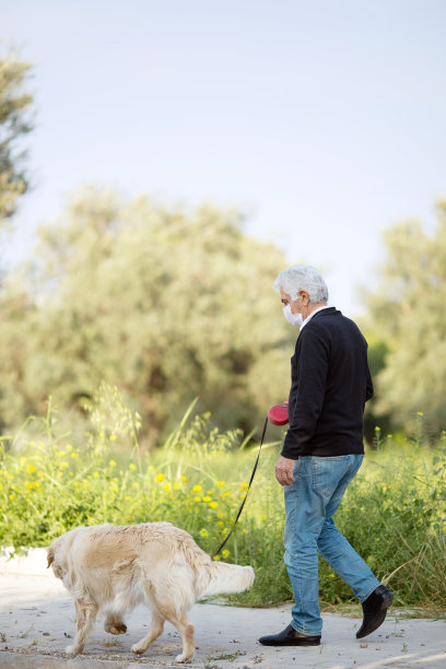 一位戴着口罩的老人和他的宠物狗在街上，因为城市的空气污染和流行病。防止病毒、感染图片下载