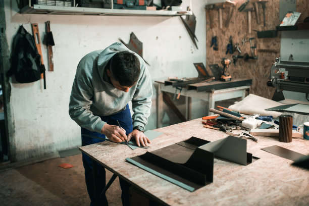 一个真正的铁匠的肖像，铁匠在他的车间里和金属一起工作，图片下载