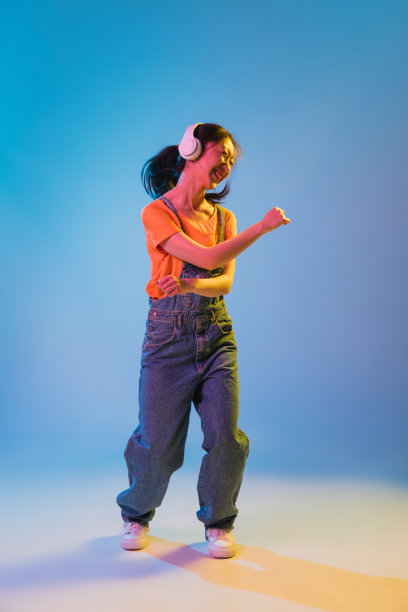 亚洲年轻女子的肖像在蓝色的工作室背景霓虹灯。人的情感、面部表情、青春、销售、广告的概念。图片下载