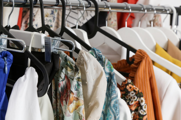 女性的时尚。不同的衣服挂在衣架上，靠近一点。图片下载