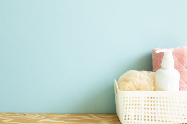 皮肤护理和水疗概念。浴室的瓶子和毛巾放在木架上的篮子里。天空的蓝色背景图片下载