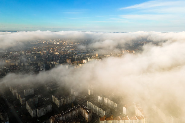 顶部鸟瞰图蓬松的白云在现代城市高层建筑。图片下载