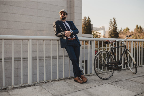 商人骑着自行车靠着栅栏站着。库存图片图片下载