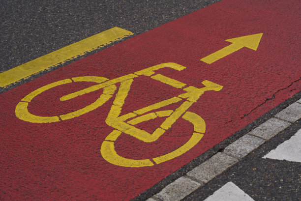 黄色自行车标志在红色自行车道上。图片下载