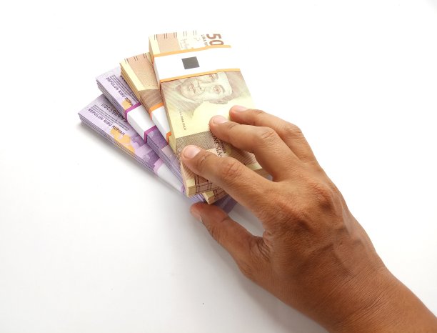 概念，俯视图手提供堆栈5000卢比和10000卢比印度尼西亚纸币在白色背景图片下载