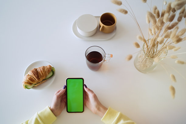 拿着智能手机在家吃早餐的青少年图片下载