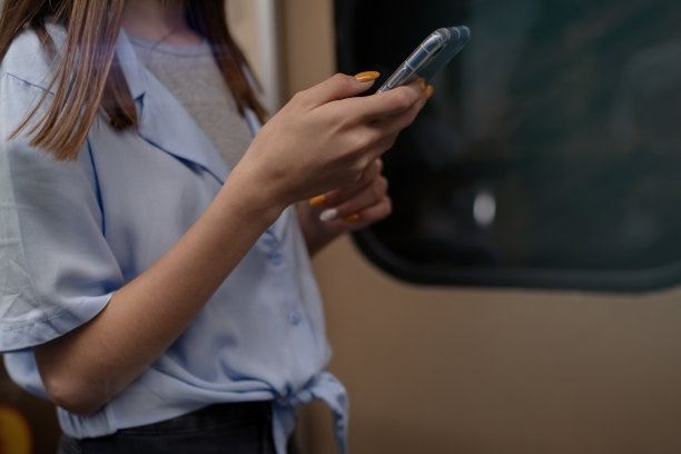 女孩坐地铁，用智能手机图片下载