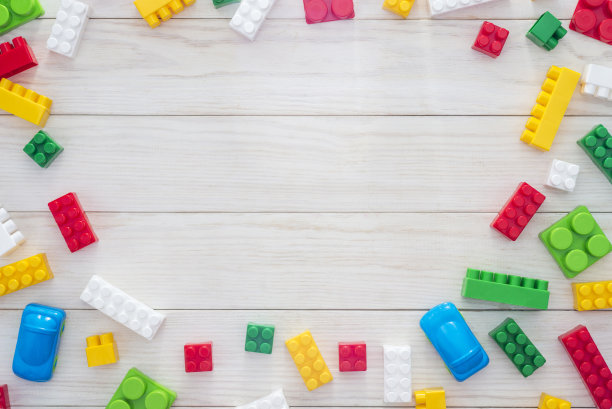 彩色塑料积木在白色的木制背景作为儿童玩具框架与文本复制空间。平的。前视图。图片下载