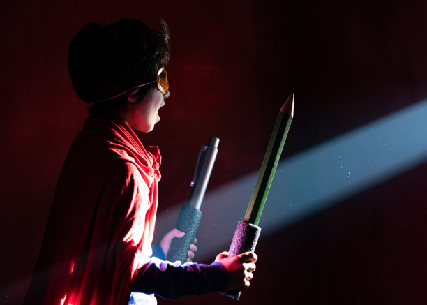 小学生穿着超级英雄服装拿着大钢笔的照片图片下载