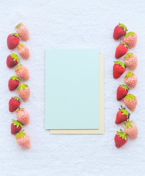 一个浅绿色卡片的模型被放置在红白草莓牌之间，在白色蓬松的布料背景上并排排列，垂直的图片下载