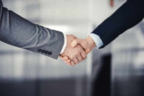 商务人士穿着西装站着握手，特写。商务沟通的概念。握手和营销图片下载