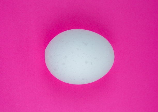 粉红色背景上的白色鸡蛋。副本的空间。极简主义，原创和创意的照片。漂亮的壁纸。复活节假期。图片下载
