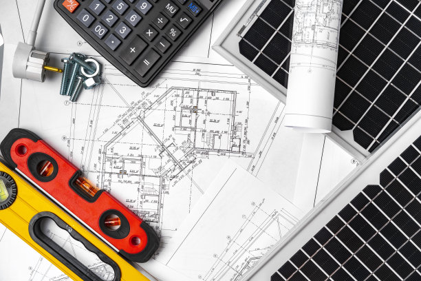 桌子上有建筑蓝图和太阳能电池板图片下载