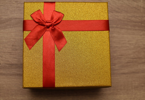 金色的礼物和红色的丝带。给爱人的礼物图片下载
