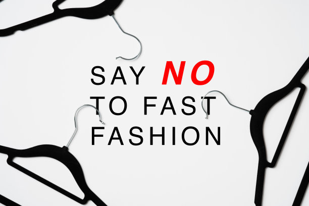 对快时尚说不的标志在白色背景的衣架堆。快时尚对环境有害图片下载