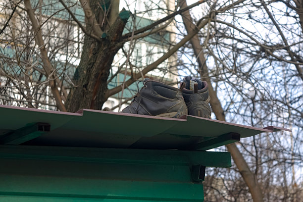 公用大楼屋顶上的旧运动鞋图片下载