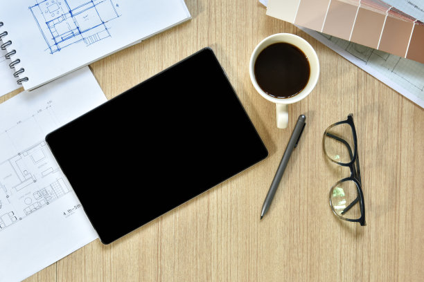 建筑师办公桌的俯视图，上面有用于绘图的钢笔在木桌上勾画出的想法，现代技术的概念是用写字板进行建筑工作图片下载