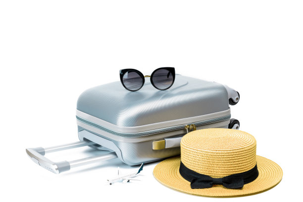 手提箱，带玩具飞机的太阳镜和草帽在白色背景孤立的旅行组成。暑假度假概念设计。图片下载
