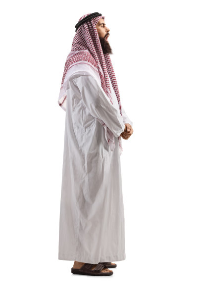 一个阿拉伯人在thobe站着唱歌的完整长度的侧面照片图片下载