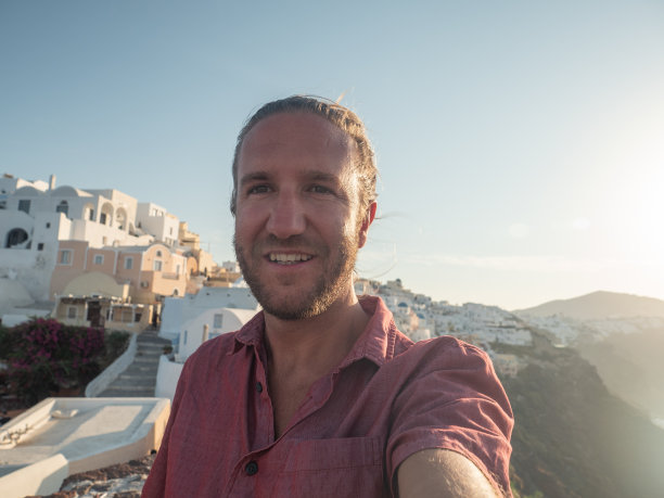 日落时分，男游客在圣托里尼岛自拍图片下载
