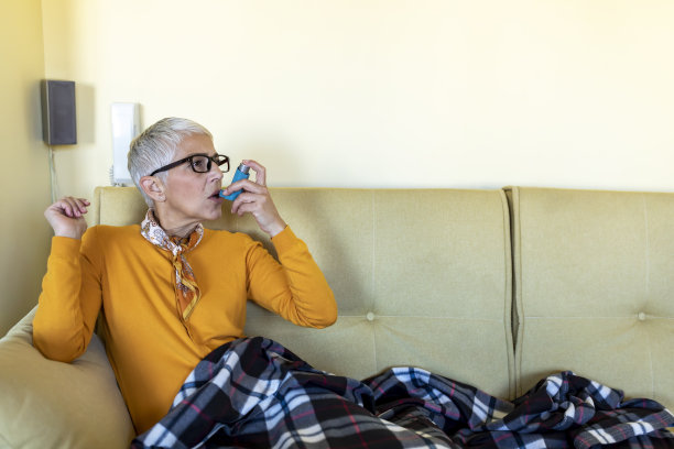 一个生病的老女人在床上有哮喘问题的照片。图片下载