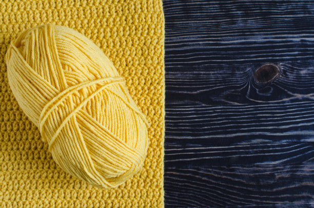 用咖啡空间的黄色线编织的背景上的一束黄色纱线图片下载