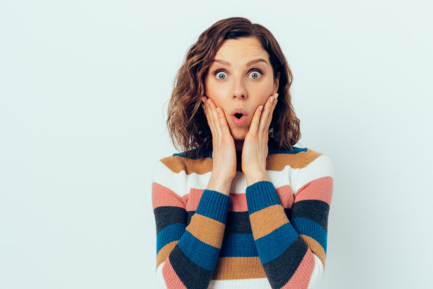 肖像美丽惊讶的年轻女子手捂在脸上图片下载