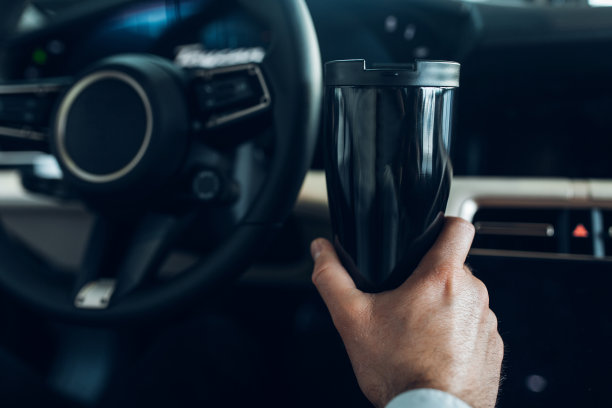 一个男人拿着热水壶开着一辆昂贵的车图片下载