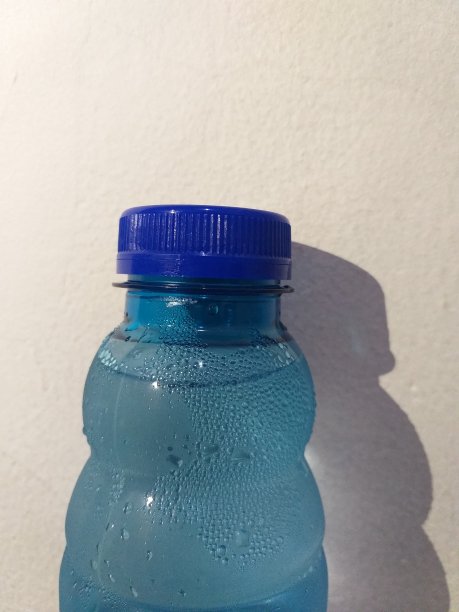 水瓶中的水点在白色的墙壁背景图片下载