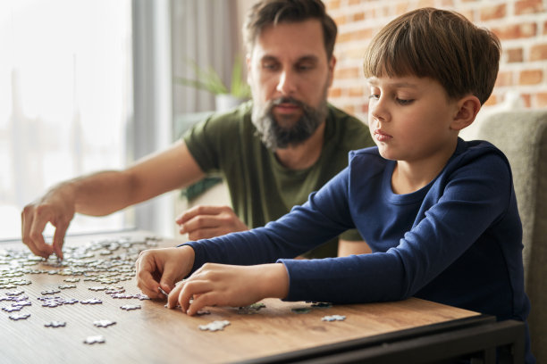近距离的父亲和儿子解决拼图图片下载