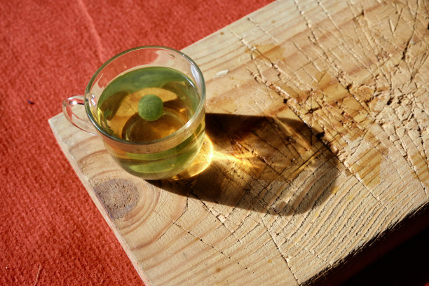 孤立的椴树茶放在玻璃杯或木盘上图片下载