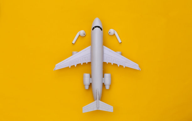 飞机和黄色背景的无线耳机。俯视图图片下载
