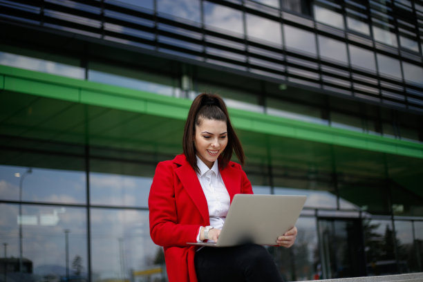 年轻的商业女性在户外使用笔记本电脑。库存图片图片下载