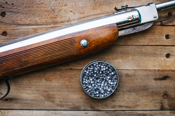 木制背景上放着气枪和子弹图片下载