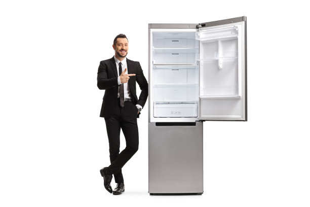 一个穿西装的男人的全身画像靠在一个空冰箱上，指着图片下载