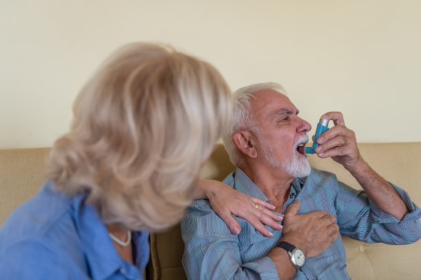 照片一个生病的老人在家与哮喘问题和他的小心的妻子。图片下载