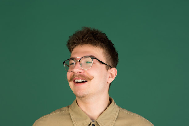 白人男子的肖像孤立在绿色的工作室背景与拷贝空间图片下载