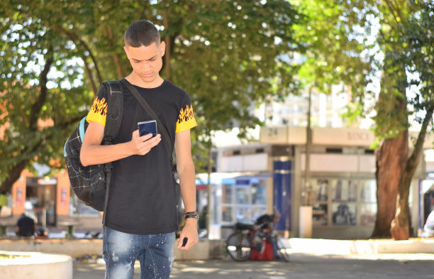 一个年轻人在公共广场上用手机图片下载