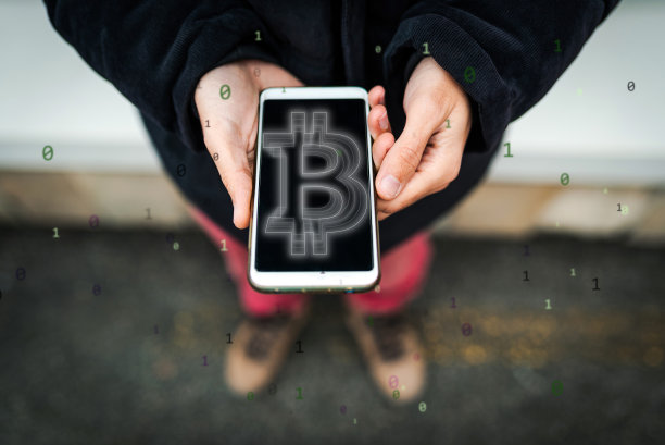 一个不知名的人用他的智能手机交易比特币。比特币/加密货币概念。图片下载