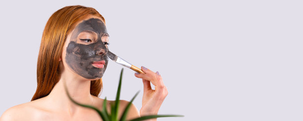 条幅，灰色背景上的长格式。红发白种人女性侧视，敷天然芦荟面膜，护肤养生。面部保湿面膜，为您的广告水疗沙龙腾出空间图片下载