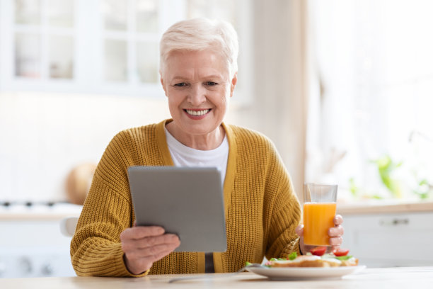 微笑着吃午饭，用着平板电脑图片下载