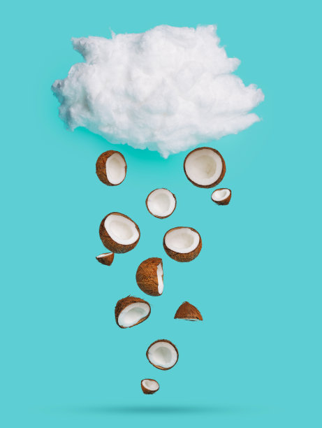 棉花云上的椰子雨点落在明亮的蓝色背景上。热带夏季组成。创意水果或素食概念。图片下载