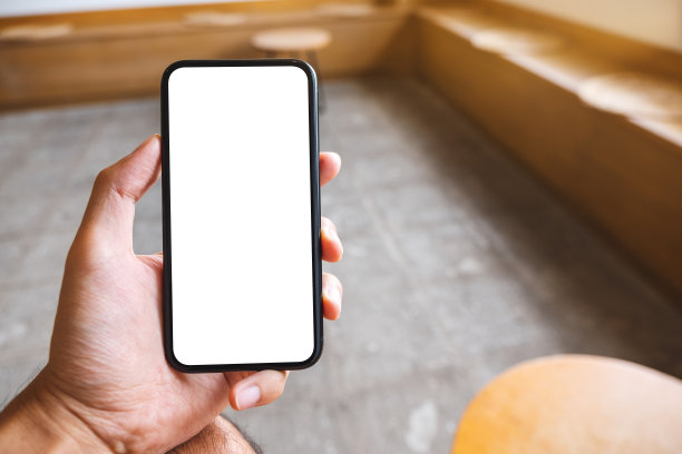 在咖啡馆里，一个手牵着手展示手机，屏幕是空白的图片下载