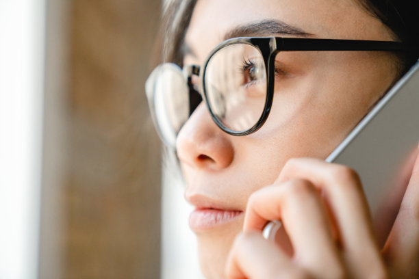 近距离肖像的亚洲人的脸，一个年轻的女孩讲电话图片下载